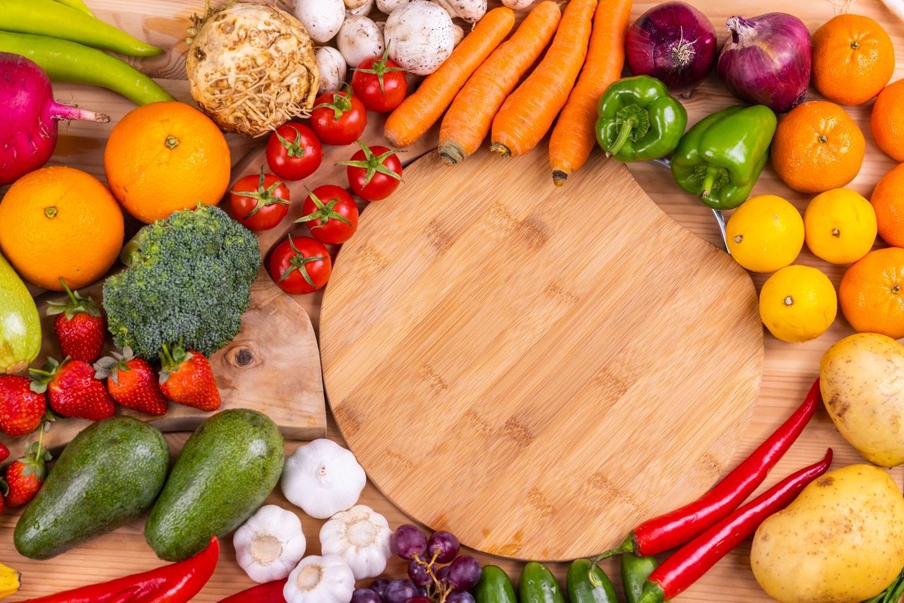 Discover a vibrant assortment of fresh fruits and vegetables arranged on a wooden board. Perfect for healthy eating inspiration.